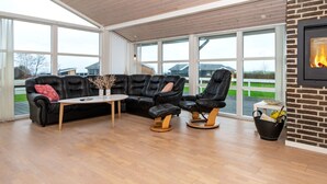 Ein modernes Wohnzimmer mit einer Eckcouch, einem kleinen Tisch und einem Kamin.