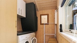 A compact laundry room with a washing machine, dryer, and a drying rack. - Holiday Home in HÃ¸jby (Hojby)