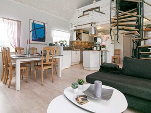 A modern living space with a dining area, kitchen, and a cozy seating area. - 6 Person Holiday Home in Lokken (Lokken)