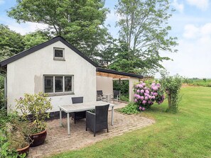 A house with a patio, a table, and chairs.