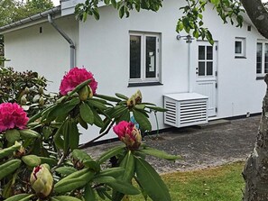 A white building with a window, a door, and a small air conditioning unit. - Holiday Home in DronningmÃ¸lle (Dronningmolle)