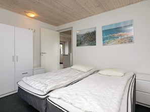 A bedroom with a bed, a wardrobe, and two paintings on the wall. - Holiday Home in Ranum (Ranum)