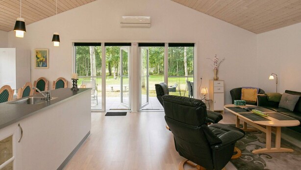 Una habitación amplia con una cocina moderna, un comedor y una zona de estar con vistas al exterior.