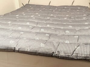 Un lit avec une couvre-lit à carreaux et des oreillers.