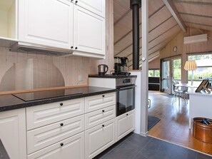 A modern kitchen with white cabinetry, a black countertop, and a built-in oven. - 6 Person Holiday Home in Vaeggerlose (Vaeggerlose)