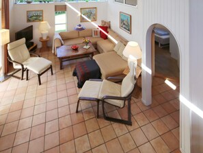 A living room with a sofa, chairs, a coffee table, and a TV. - Holiday Home in Tisvildeleje (Tisvildeleje)