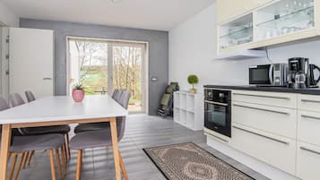 Cocina moderna con comedor, vista por la ventana y microondas integrado.