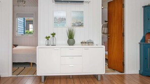 A room with a white cabinet, a wooden door, and a window with blue shutters. - Holiday Home in Juelsminde (Horsens)