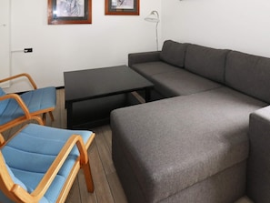 A modern living room with a grey sofa, two blue chairs, a black coffee table, and a floor lamp. - 6 Person Holiday Home in Hadsund (Hadsund)