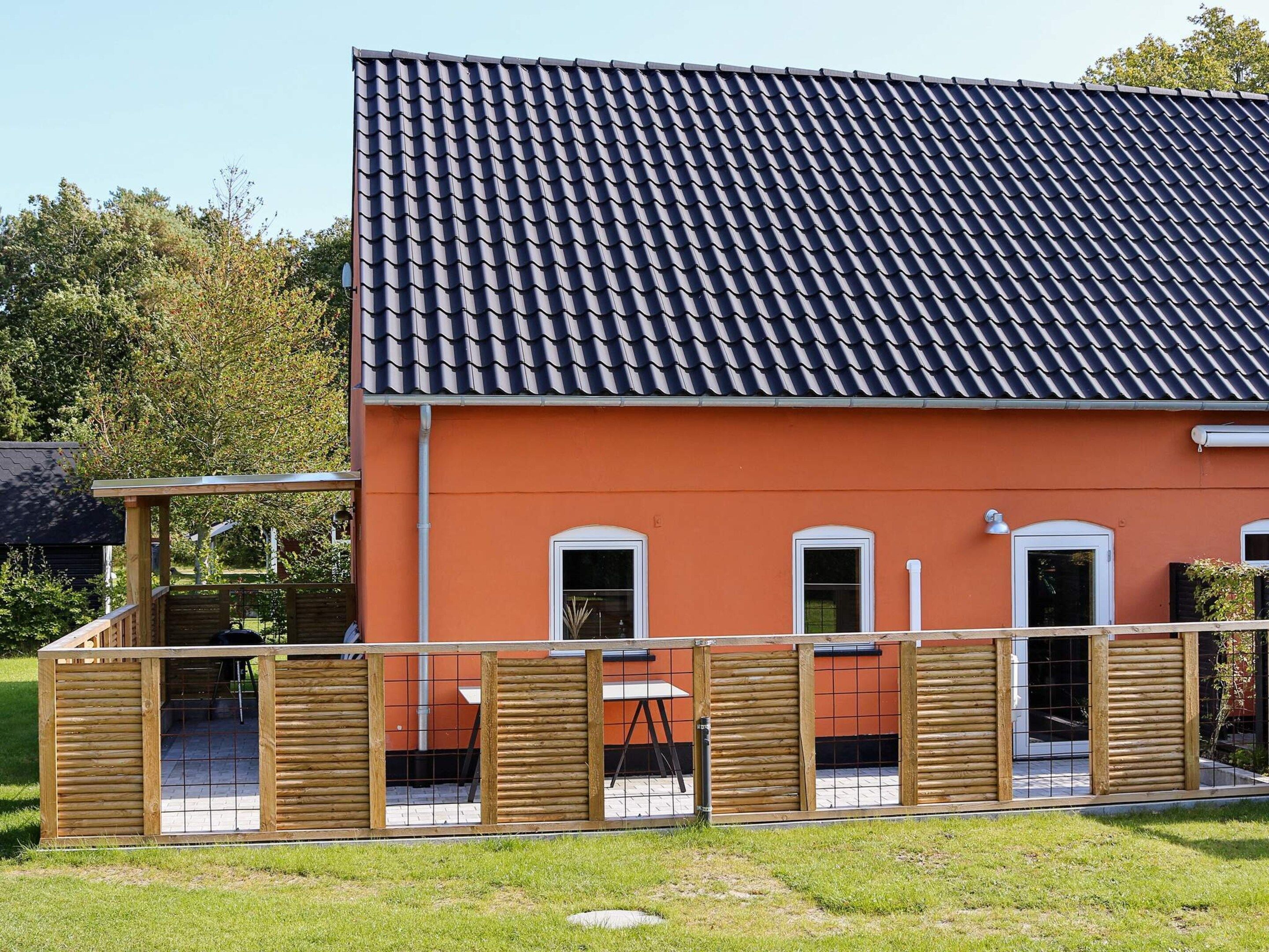 A building with a tiled roof and a fenced outdoor area.