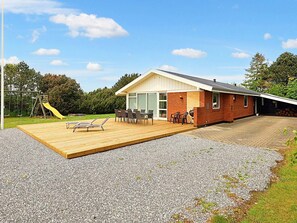 A modern house with a patio, a play area, and a barbecue setup. - 8 Person Holiday Home in Vaeggerlose (Vaeggerlose)
