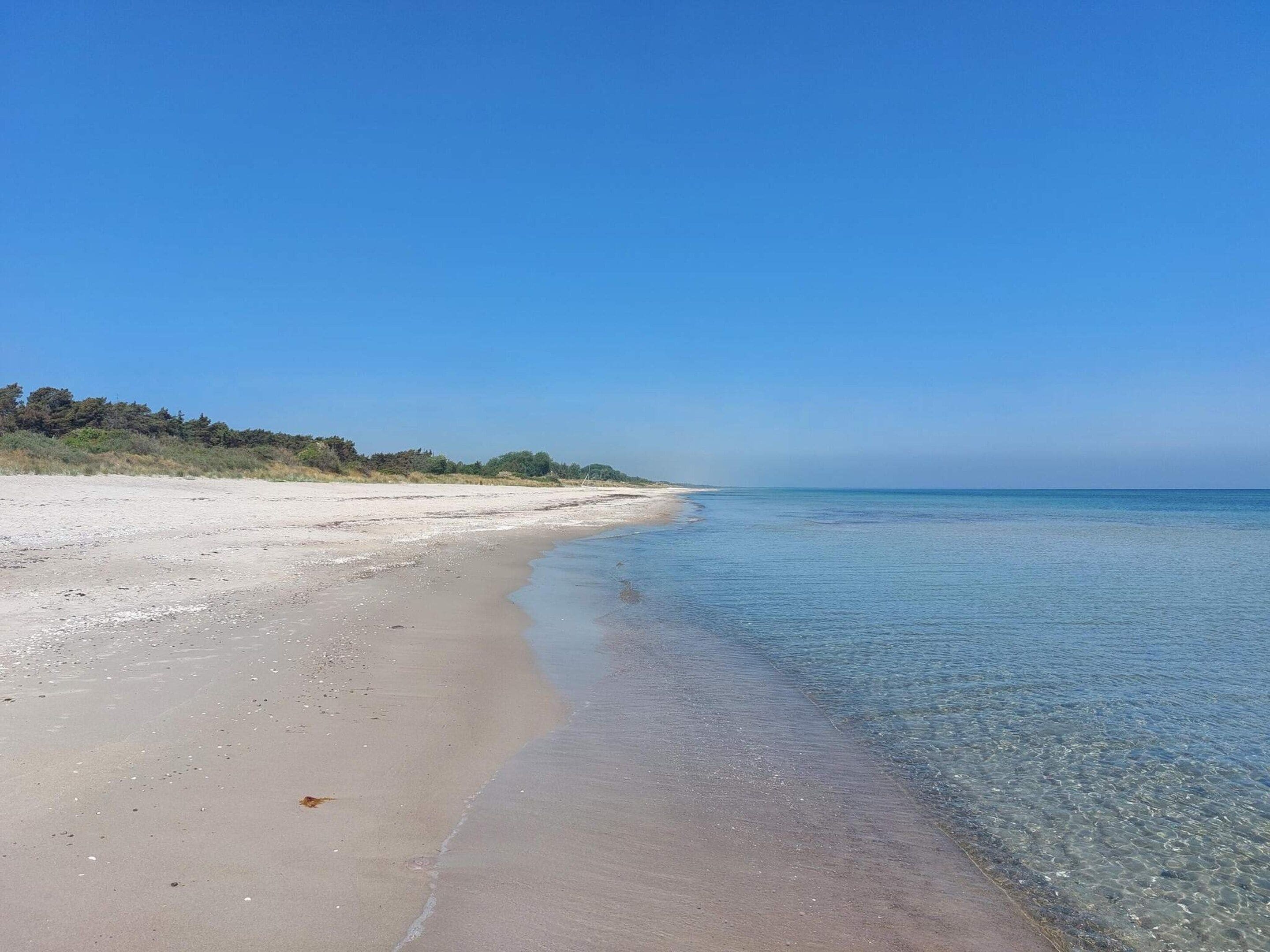 Una playa con aguas cristalinas y una orilla arenosa.