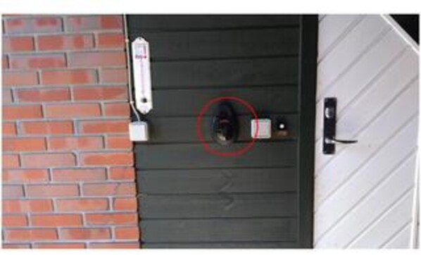 Une porte équipée d’une caméra de surveillance, une boîte aux lettres et une boîte aux lettres fixée au mur.