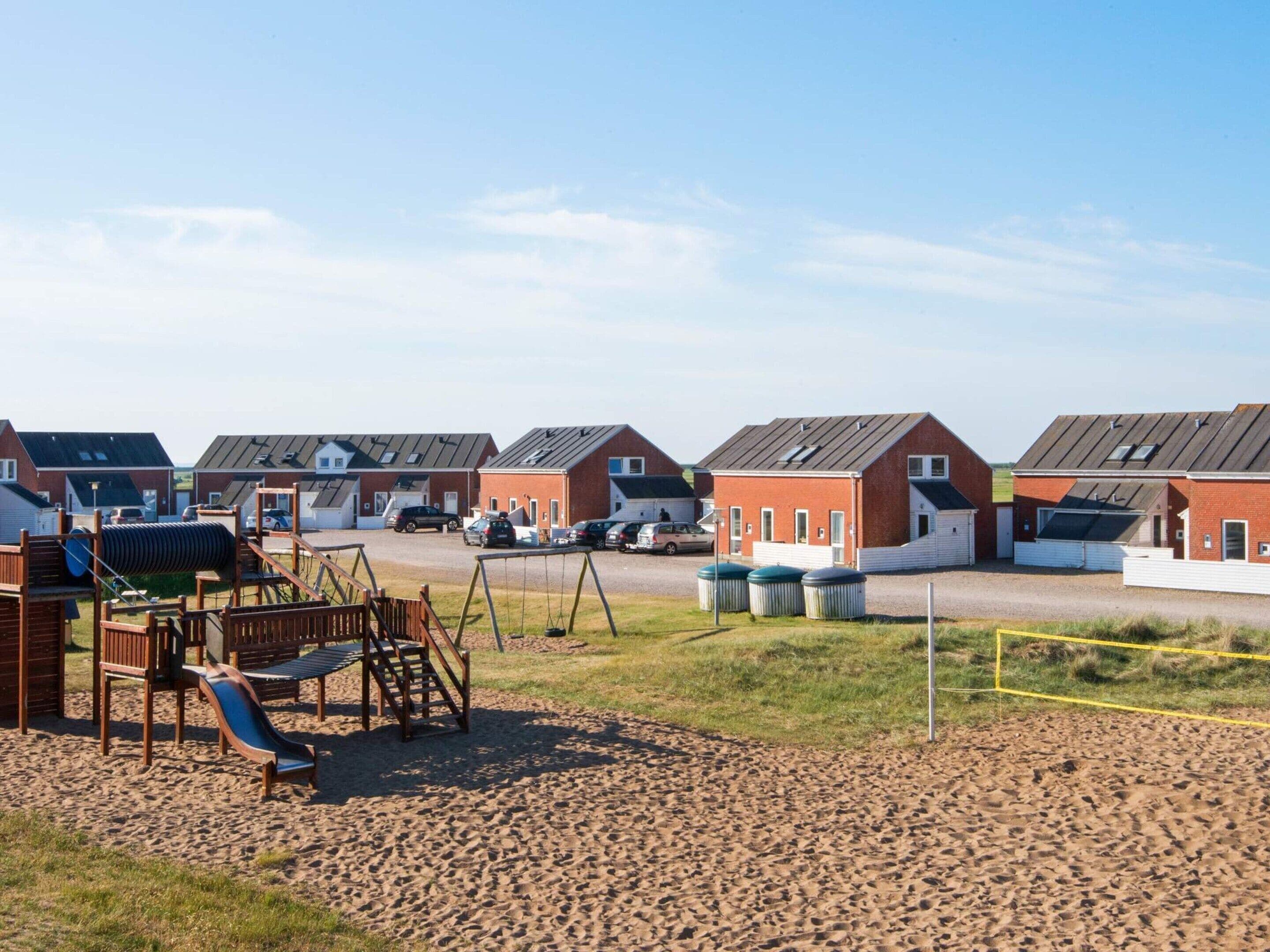 A residential area with multiple houses, a playground, and a parking lot.
