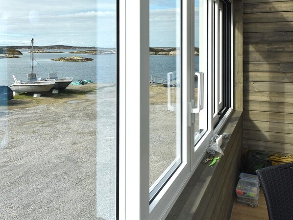 A view from a room with a large window overlooking a marina with boats and a calm body of water.