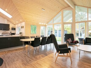A modern kitchen with a dining area, large windows, and a view of the outdoors. - Holiday Home in Hals (Hals)
