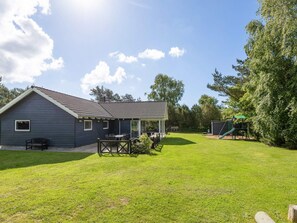 A residential property with a house, a covered patio, a play area, and a lawn. - Holiday Home in Hals (Hals)