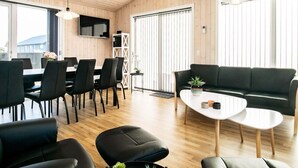 Un intérieur moderne comprenant un coin repas, un canapé et un téléviseur.