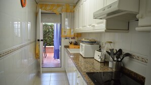 Una cocina con armarios blancos, encimera de granito y placa de inducción negra.