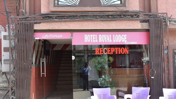 A hotel entrance with a reception desk and chairs outside. - Hotel Royal Lodge (Islamabad)