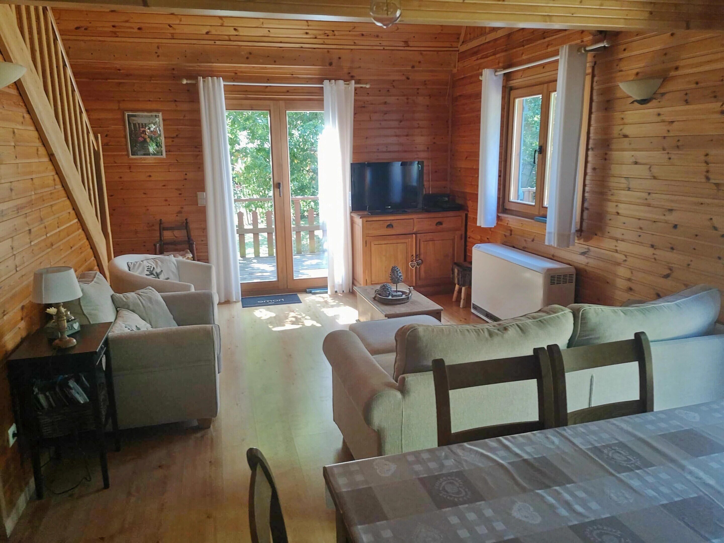 A cozy cabin with a living area featuring a sofa, a small table, and a television.