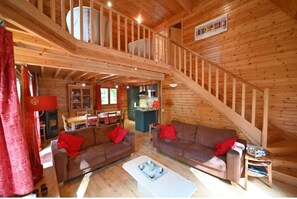 L’intérieur d’une cabane en bois comprend une chambre à coucher située en mezzanine, un coin repas et une cuisine.