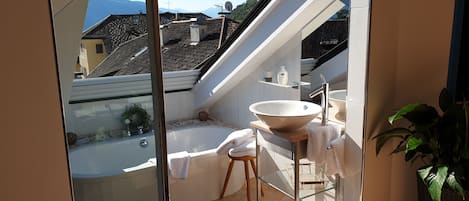 Bathtub, hair dryer, bathrobes, towels
