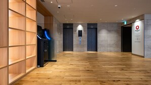 A spacious lobby with wooden flooring, a reception desk, and a sign for the Daiei House Group. - DEL style Ikebukuro Higashiguchi by Daiwa Roynet Hotel (Tokyo)