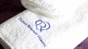 Una toalla blanca con bordado de texto y un logotipo.