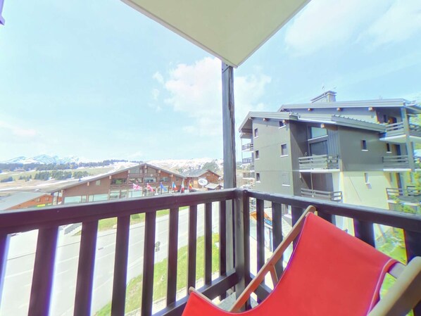 A balcony with a view of a mountain and buildings.