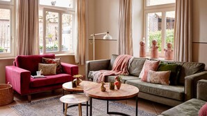 A cozy living room with a red armchair, a grey sofa, and two round coffee tables. - Holiday Home in Baarlo With Hot Tub (Baarlo)
