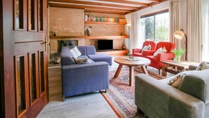 A cozy living room with a fireplace, bookshelves, and comfortable seating.