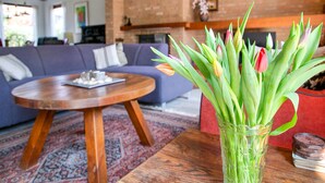 A living room with a sofa, a coffee table, and a vase with tulips.