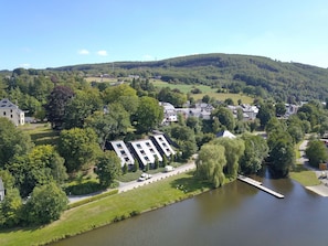 A residential area with a river, houses, and a hill in the background. - Apartment in Vielsalm Near Les Doyards Park (Vielsalm)