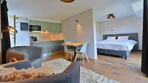 A compact living space with a kitchenette, a dining area, and a bedroom. - Apartment in Vielsalm Near Les Doyards Park (Vielsalm)
