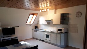 A compact kitchen with a built-in oven, microwave, and a small window above the sink. - Black Forest Farmhouse in Charming Location (Hofstetten)