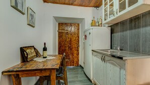 Una piccola cucina con un tavolo di legno, un frigorifero e degli armadietti.