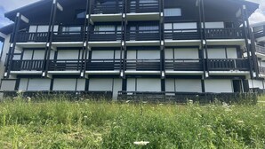 Een gebouw met meerdere verdiepingen, balkons en grote ramen.