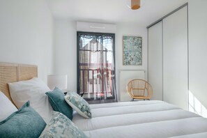 Une chambre à coucher avec un lit, une chaise, une fenêtre et une porte.