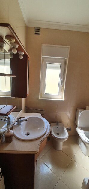 Bañera con ducha, secador de pelo, bidet, toallas