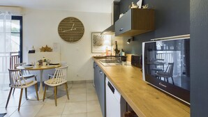 Una cocina moderna con encimera de madera, horno empotrado y un amplio ventanal.
