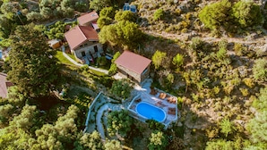 An aerial view of a property with a swimming pool, stone buildings, and surrounding greenery. - Traditional Apartments Elafos (Kissamos)