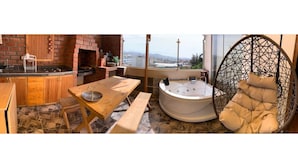 A kitchen with a brick oven, a dining table with benches, a hot tub, and a hanging chair. - IDEAL for WORK and confort JACUZZI and GRILL (Arequipa)