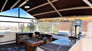 A patio area with a foosball table, a grill, and a coffee machine. - IDEAL for WORK and confort JACUZZI and GRILL (Arequipa)