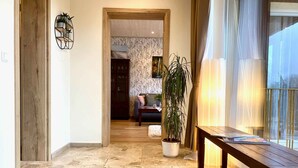 Un pasillo con piso de piedra que conduce a una sala de estar con sofá y mesa de centro.