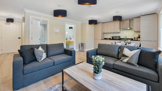 A modern living room with two grey sofas, a coffee table, and pendant lights. - Deanway Serviced Apt Chalfont St Giles (Chalfont St Giles)
