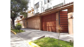 Stylish Mediterranean-style building with a garage and parking area.