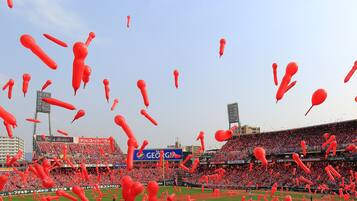 A stadium filled with spectators and red balloons.