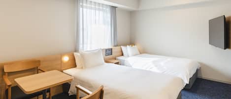 A hotel room with a bed, a desk, a chair, and a television.