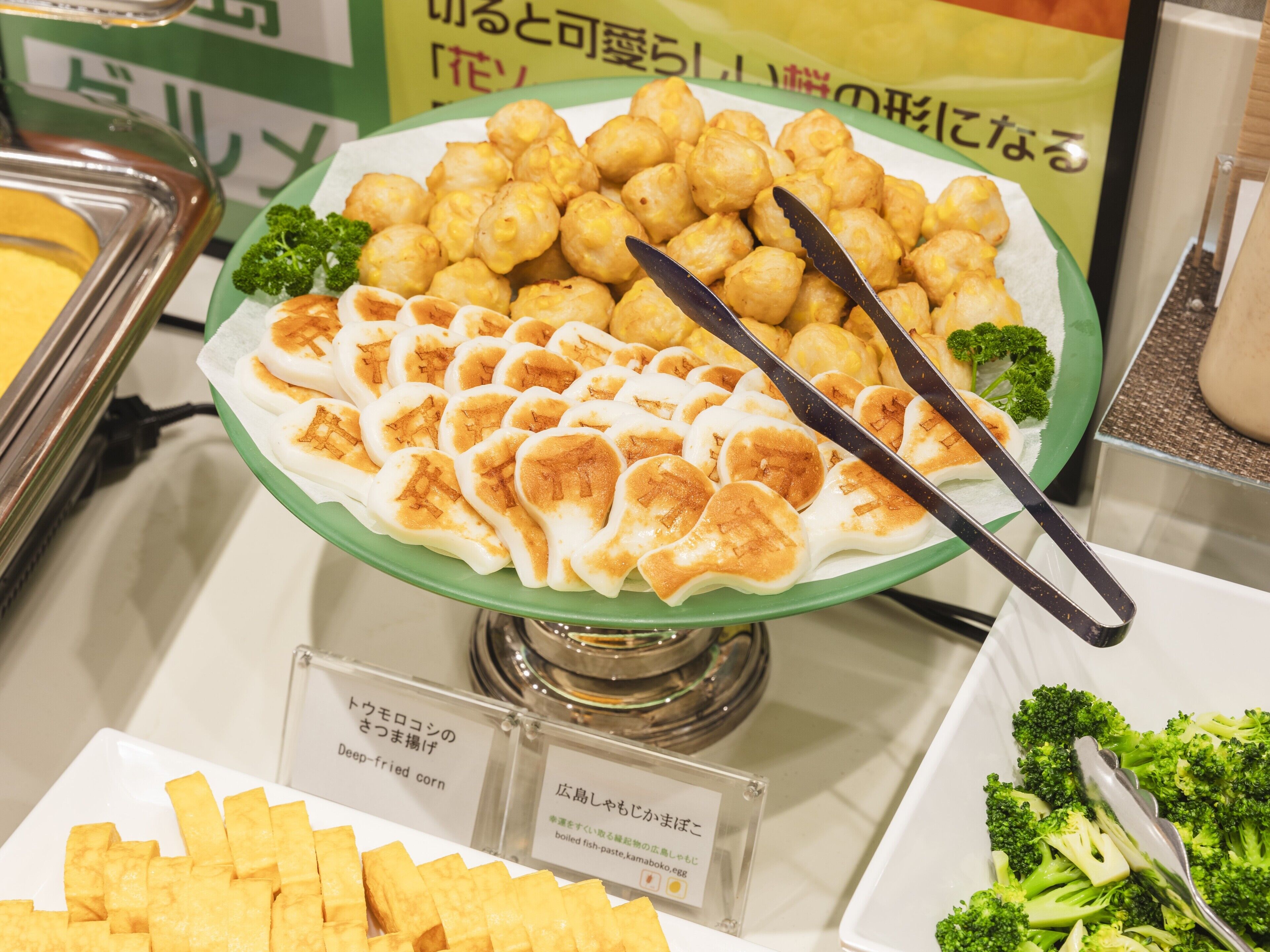 A buffet with deep-fried corn, a dish with a lattice pattern, and broccoli.